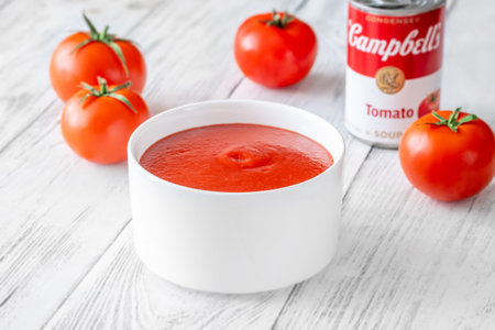 Clean editorial food scene combining homemade soup presentation with iconic packagingの写真素材