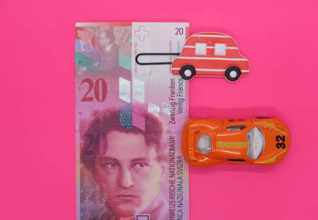 Swiss banknote and two toy carsの写真素材