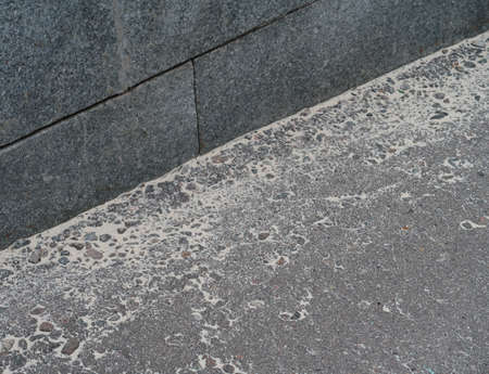 Granite curb and white sand on dark asphaltの写真素材
