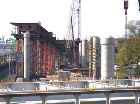 Construction of an automobile overpass next to the existing railway line and a residential neighborhood, metal structures and massive concrete supportsの写真素材