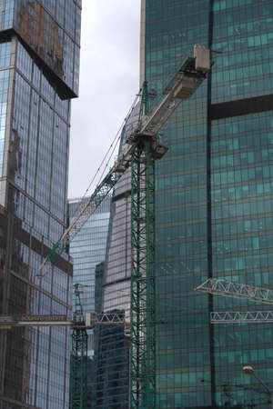 Construction cranes against the background of glass facades of high-rise buildings in Moscow Cityのeditorial素材
