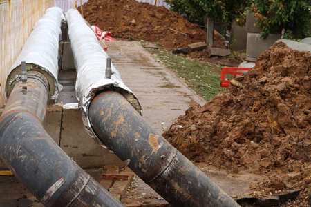 Two pipes partially covered with thermal insulation, laying of pipes with hot waterの写真素材