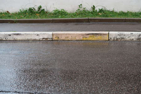 Wet asphalt, sidewalk, curb and lawn, minimalism, autumnの写真素材