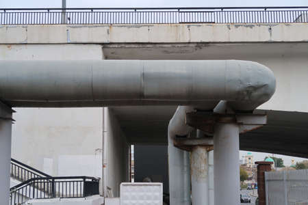 Powerful pipes for supplying heat from a heating station, passing under a road bridge