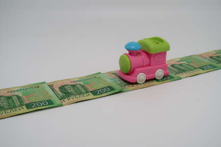 Toy locomotive on money road, vacation train ride, moneyの写真素材