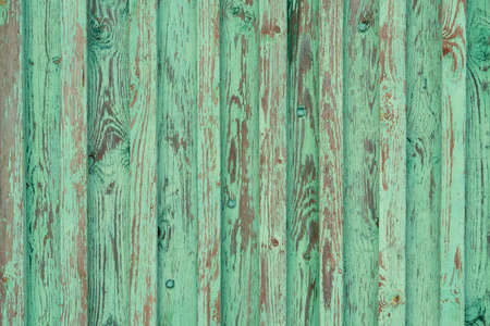 Peeling plank wood fence painted with bright green beauty, backgroundの写真素材