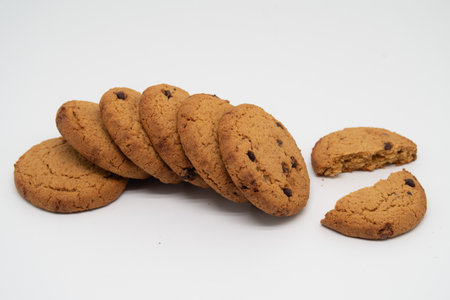 A stack of round oatmeal cookies lies on the table, one is broken in half, bakery products