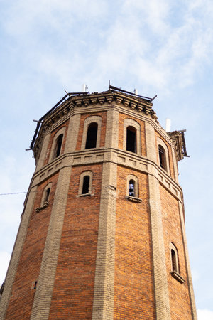 White and red brick water tower with arched windows and cornice, backgroundの写真素材