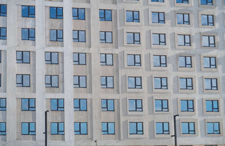 The blue sky is reflected in the same windows on the facades of the office building, background