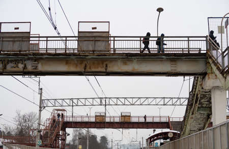 Pedestrian crossings over a railway station, outlines of figures of pedestrians, background