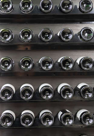 The bottoms of bottles with wine on a wooden rack, background, strict colors