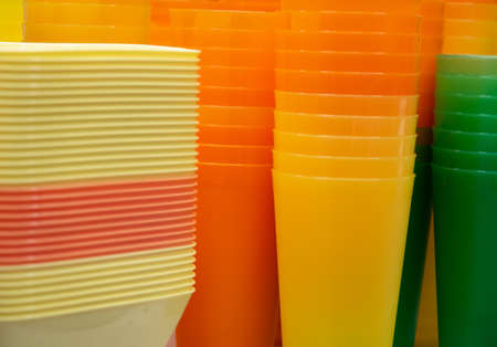 Many plastic containers of various colors, bright background