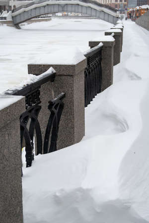 February 13, 2021, Moscow, Granite fence and sidewalk on Shluzovaya embankment are covered with snow, heavy snowfall, backgroundのeditorial素材