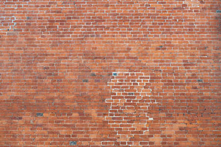 Old smooth red brick masonry with traces of restoration, marked with white mortar, backgroundの写真素材
