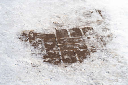 Thawed patches in the trampled snow on a railway platform, winterの写真素材