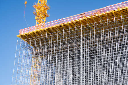 Volumetric metal grating, future facade of a building under construction, construction crane, background, 2021の写真素材