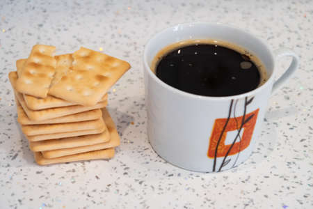 Cup of hot drink and stack of several biscuits, instant chicory