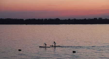 Rowers on boards at sunset on Volga, Samara, August, 2021