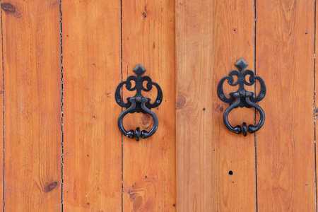Metal handles on wooden doors, wooden background