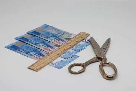 Ruler and scissors are on Russian banknotes, reduction of financial expenses, family budget.の写真素材