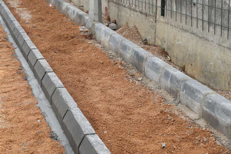 Footpath construction, curbstone and lapped soil, construction background.