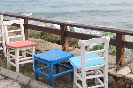 A table in a cafe on the embankment against the background of a wooden fence and the sea, Alanya, Turkey, November 2021.の写真素材