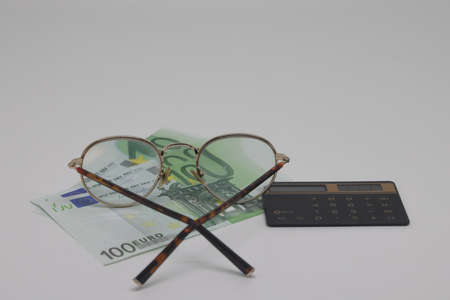 A pair of round glasses with a banknote inside. Economic concept.