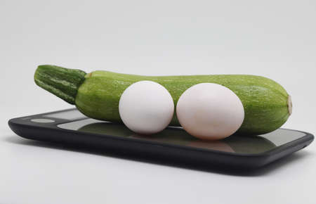 Zucchini and two raw chicken eggs lie on a cutting boardの写真素材