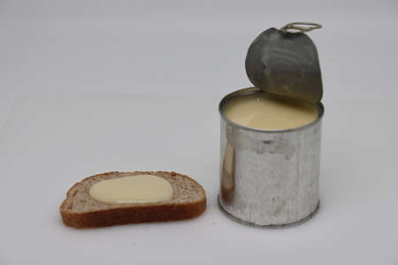 Puddle of condensed milk flows from levitating jar, can opener, black bread.