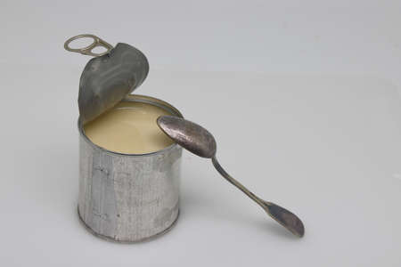 Can of sweetened condensed milk on white background.