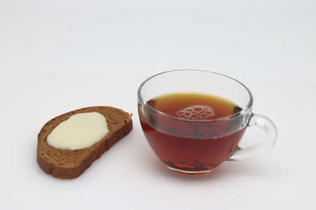 Sandwich from muffin with condensed milk in plate, tea and spoon on wooden table. Top view.