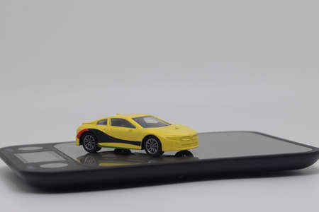 Toy car on kitchen electronic scales, the cost of buying and operating a car.の写真素材