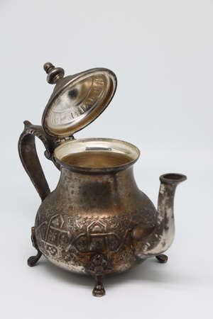Antique metal teapot on a white background. Close-up of an old Arabic teapotの写真素材