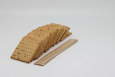 Cookies with sesame seeds on a light background. Square cookies, crackersの写真素材