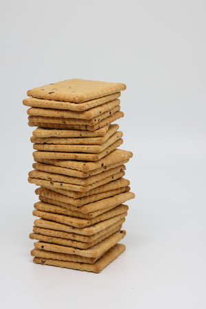 Cookies with sesame seeds on a light background. Square cookies, crackers