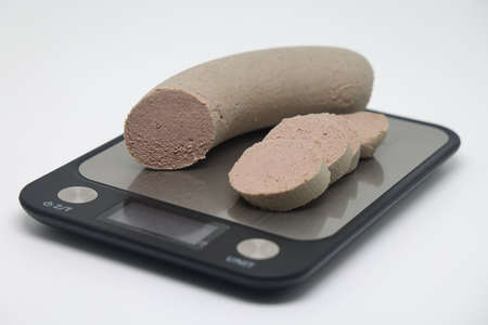 Liver sausage on an electronic kitchen scale, accurate calorie counting, proper nutritionの写真素材