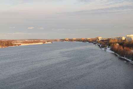 river on a sunny evening. Trees and shrubs. Landscape of winter nature, river banks overgrown with...