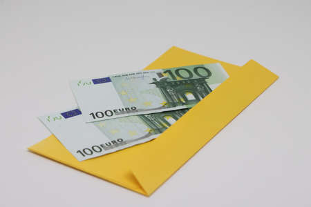 One hundred dollar bills in a white envelope on a black background. Bribery concept. Salary in envelopes. financial fraud.の写真素材