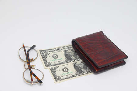 Brown wallet with banknotes and glasses. brown frame. Symbol of accounting and family finance planningの写真素材