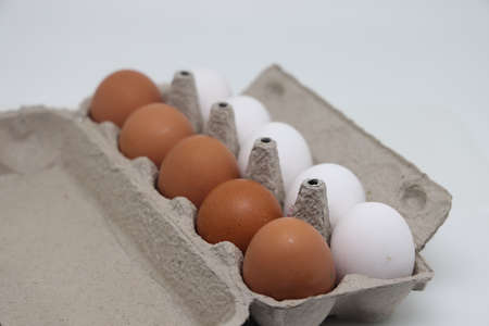 Ten eggs in a carton. A dozen raw white and brown eggs