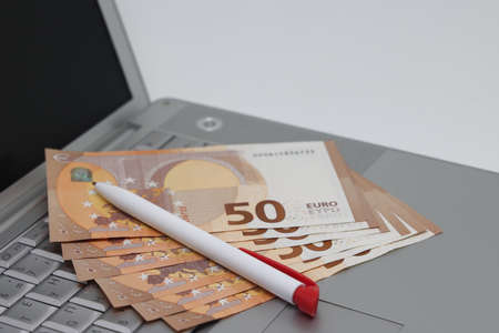 Banknotes and glasses lie on the laptop keyboard, freelance earningsの写真素材