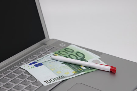 Banknotes and glasses lie on the laptop keyboard, freelance earningsの写真素材