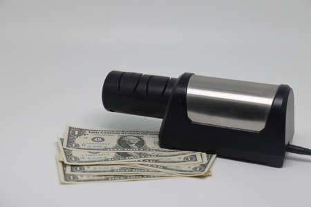 Banknotes and an electric knife sharpener. world financial crisis. The fight against inflation