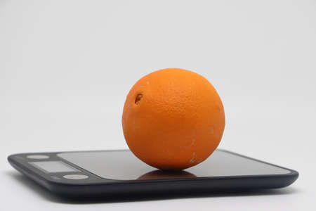 Orange on the scales. Weight loss, diet and weight control. Still life with healthy food and scales. Health food. The concept of a healthy lifestyle. weight controlの写真素材