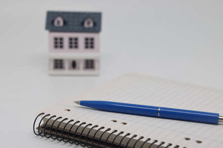 The pen lies on a blank page of the weekly magazine on the toy house. Buying a home and mortgageの写真素材