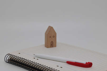 The pen lies on a blank page of the weekly magazine on the toy house. Buying a home and mortgageの写真素材