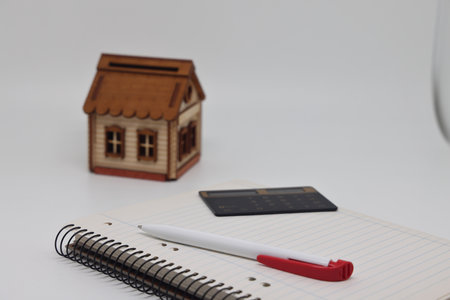 The pen lies on a blank page of the weekly magazine on the toy house. Buying a home and mortgageの写真素材