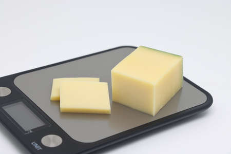 Pieces of cheese on the scales. Weight loss, diet and weight control. Still life with healthy food and scales. Health food. The concept of a healthy lifestyle. weight controlの写真素材