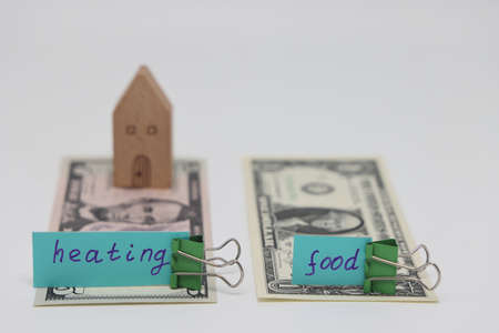 Dollar bills inserted into the radiator slots of the heating system, the increase in the cost of heat, fuel crisis, utility billsの写真素材