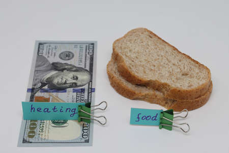 Dollar bills inserted into the radiator slots of the heating system, the increase in the cost of heat, fuel crisis, utility billsの写真素材